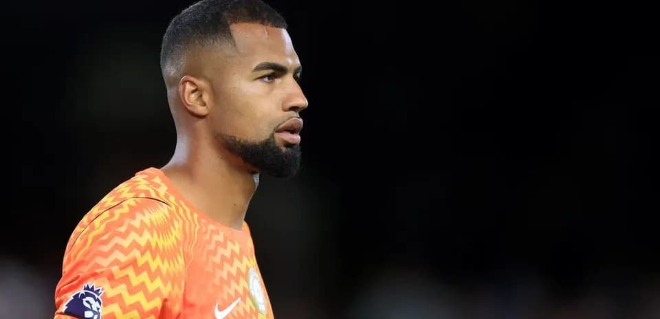 Goalkeeper in orange kit during match preparation
