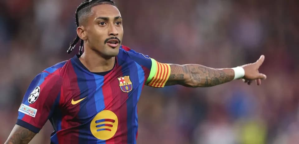 Player in FC Barcelona kit directing teammates on field