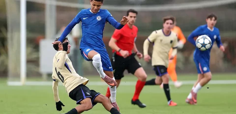Player from Chelsea evading a sliding tackle during match