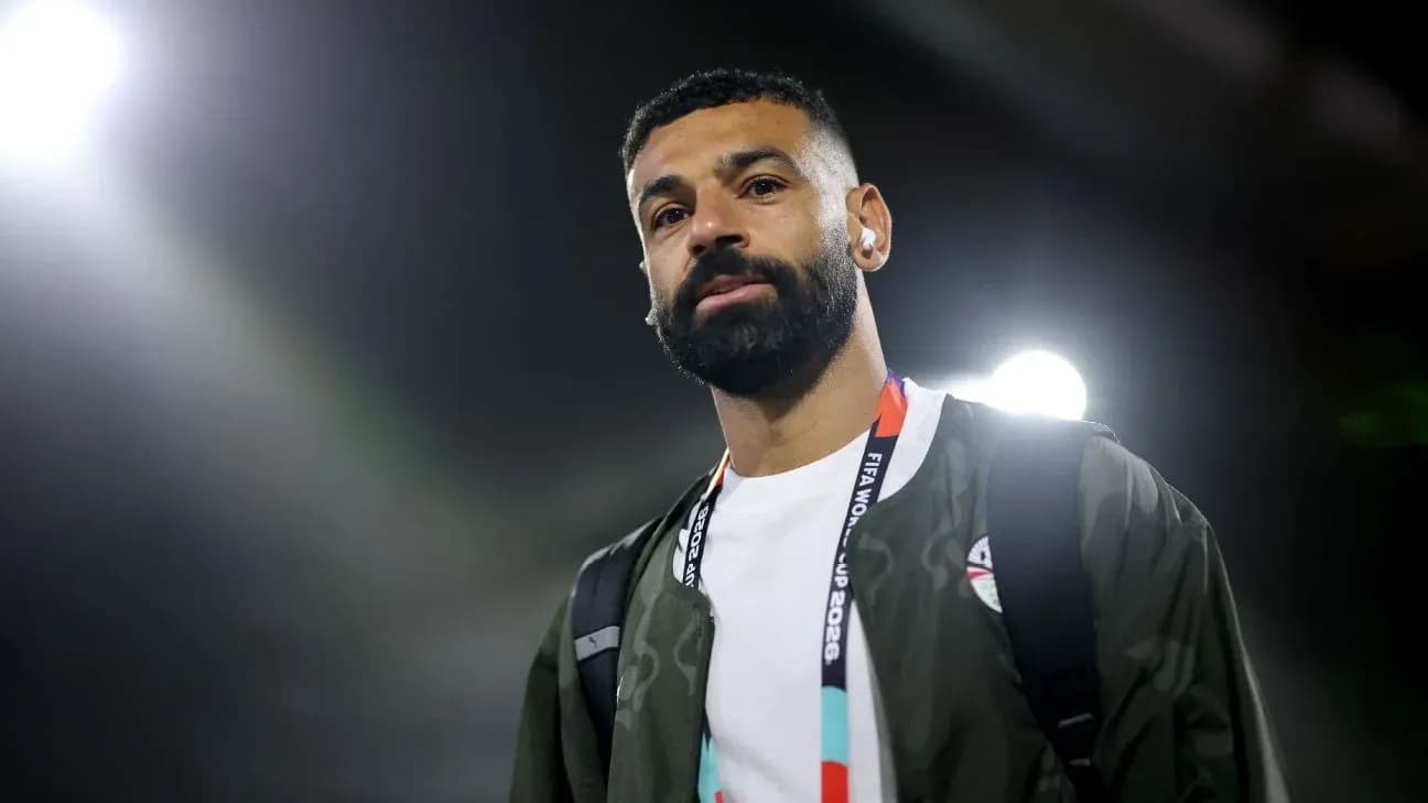 Player walking with headphones and backpack at stadium
