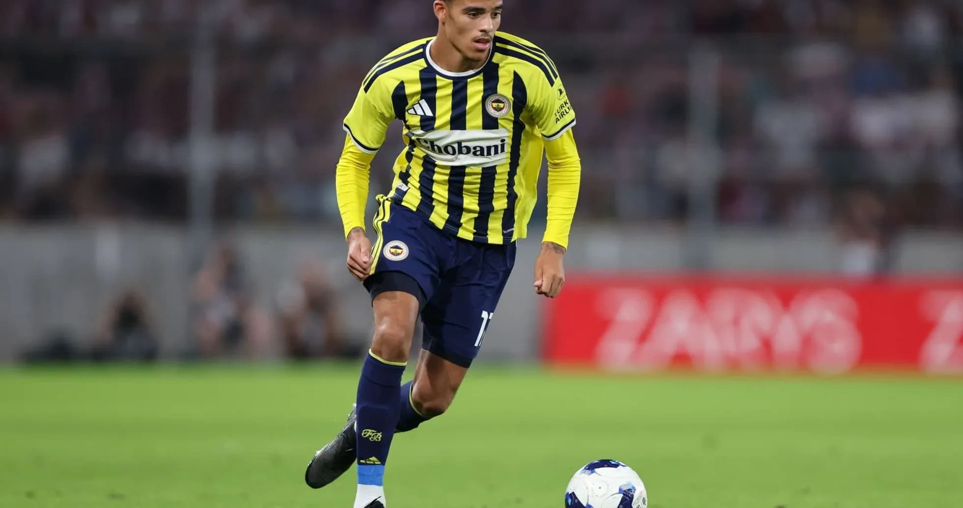 Fenerbahçe player dribbling the ball on field