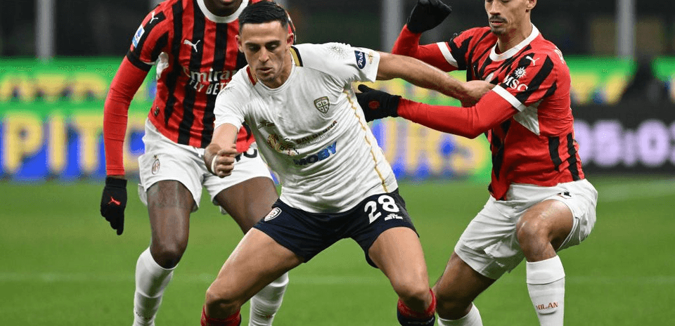 AC Milan players challenging Cagliari player for the ball