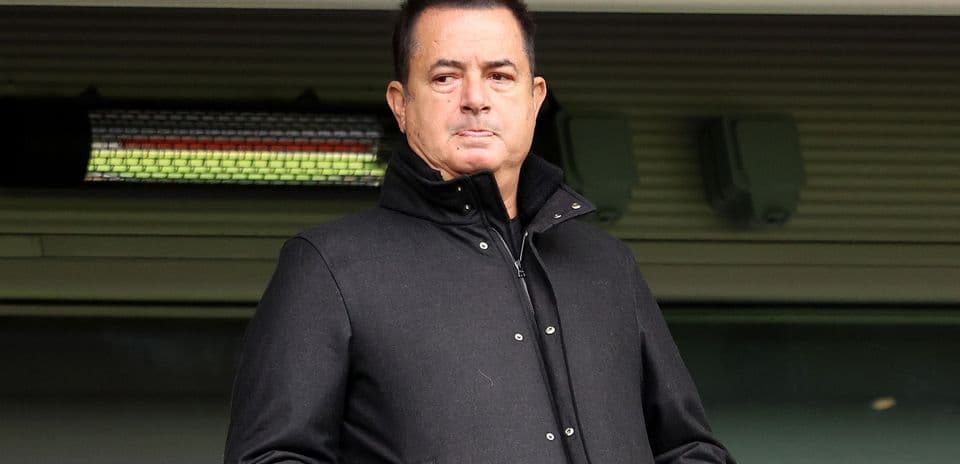 Man standing in a stadium wearing a black coat