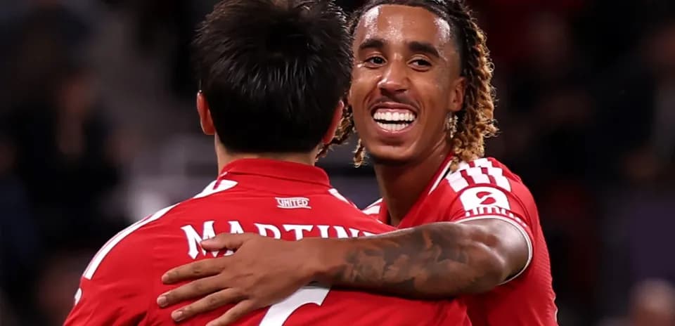 Two players celebrating a goal in red jerseys