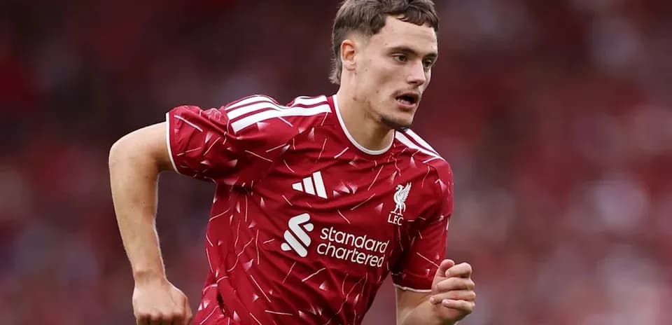 Player running on the pitch wearing Liverpool kit