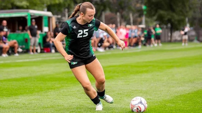Player 25 kicking soccer ball during practice