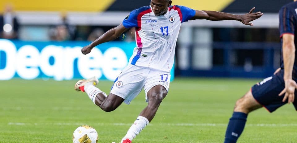 Haitian player kicking the ball during match