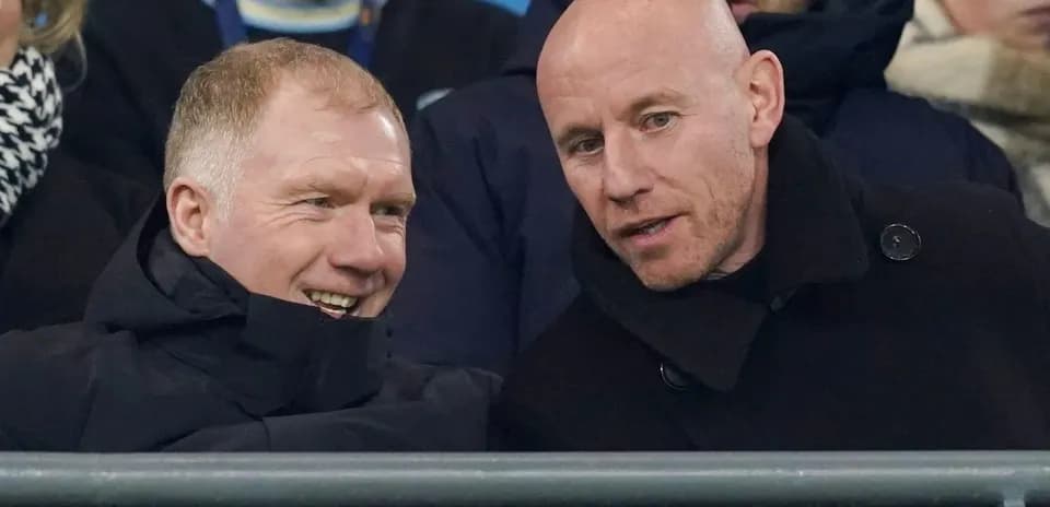 Two men conversing in stadium seats during match
