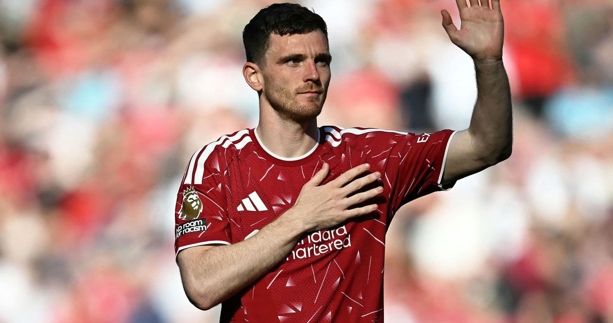Player waving to fans wearing red jersey