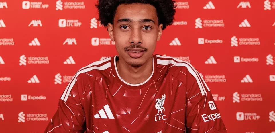 Player signing contract in Liverpool jersey