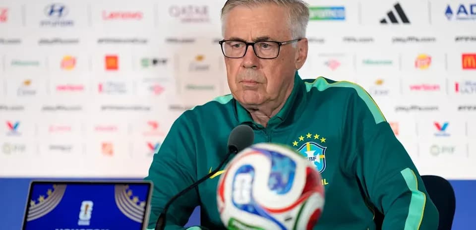 Manager at press conference with football and laptop