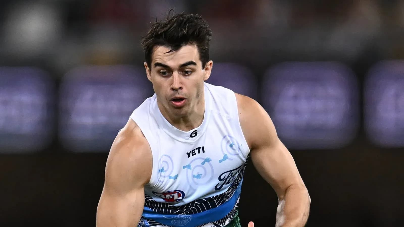 Player sprinting during an AFL match