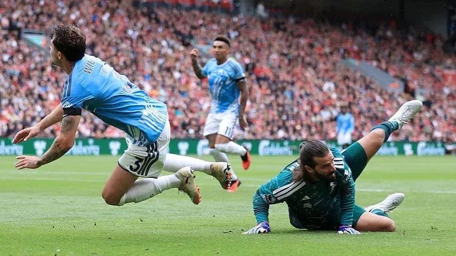 Goalkeeper saves shot as player falls during match