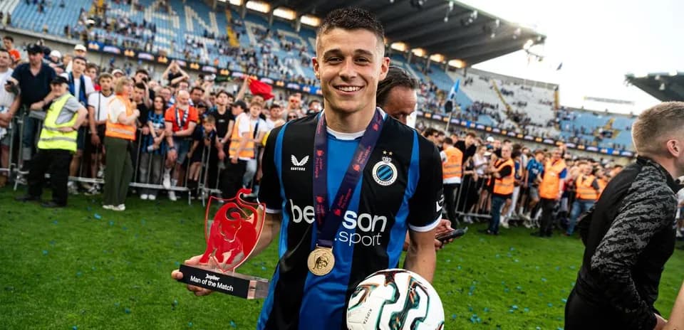 Player holding Man of the Match trophy on field