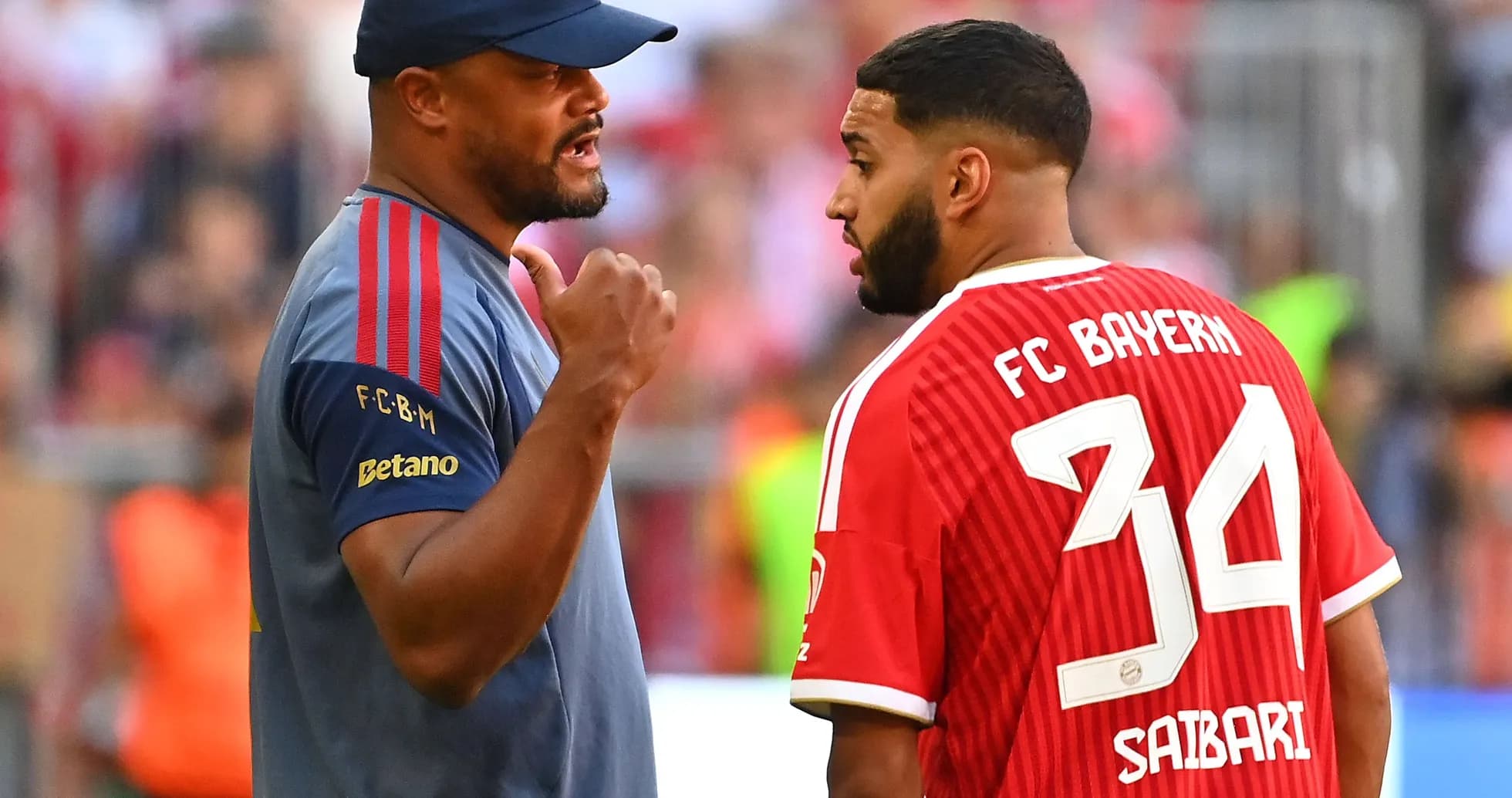 Coach discussing with player wearing Bayern jersey