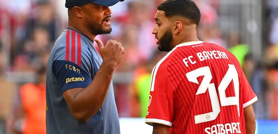 Coach discussing with player wearing Bayern jersey