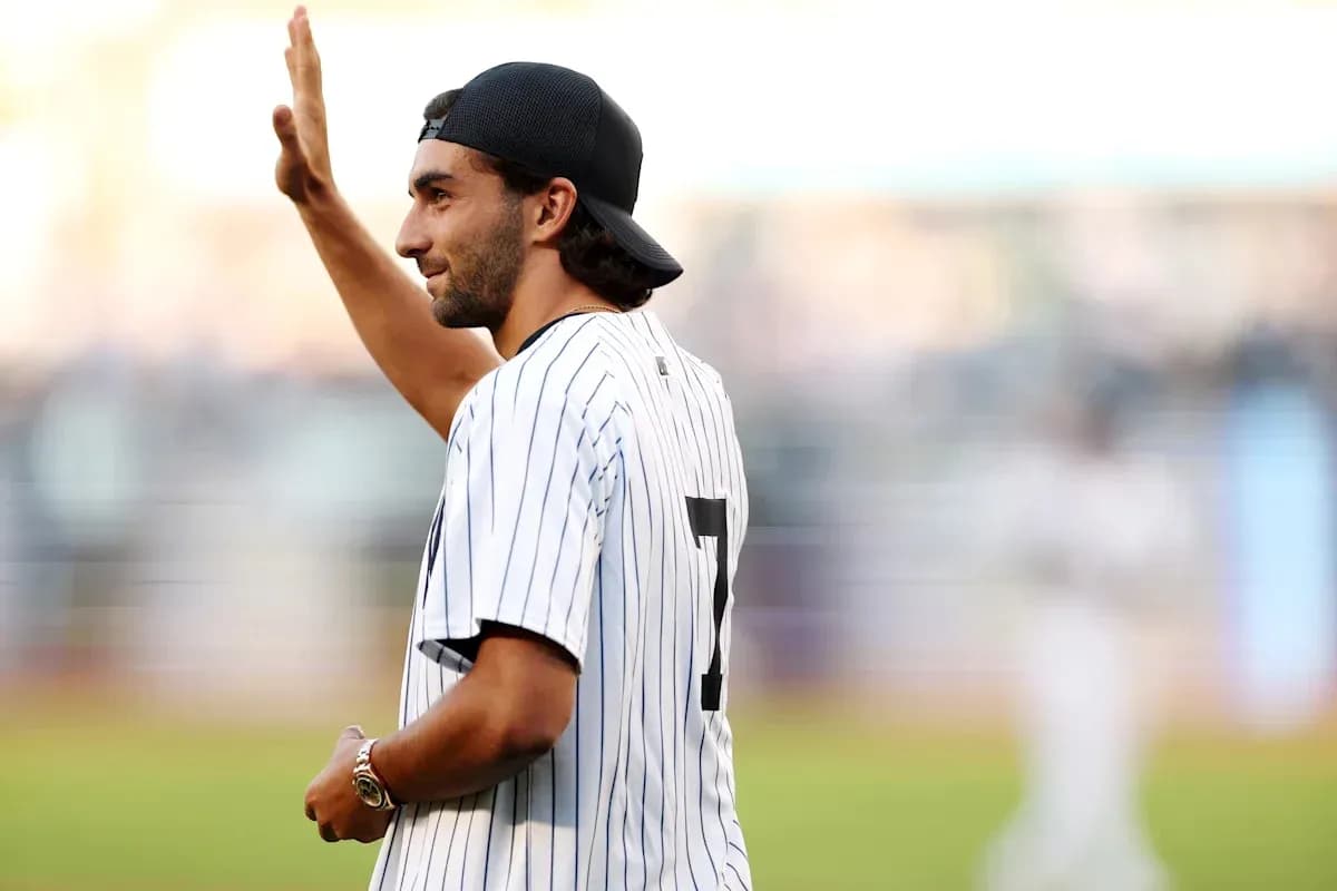 Man waving while wearing a baseball jersey