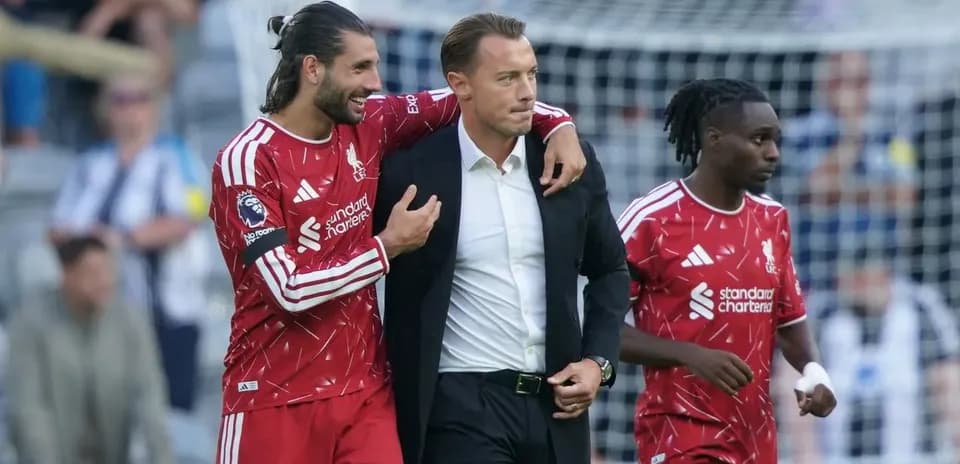 Liverpool players interacting with coach on sideline