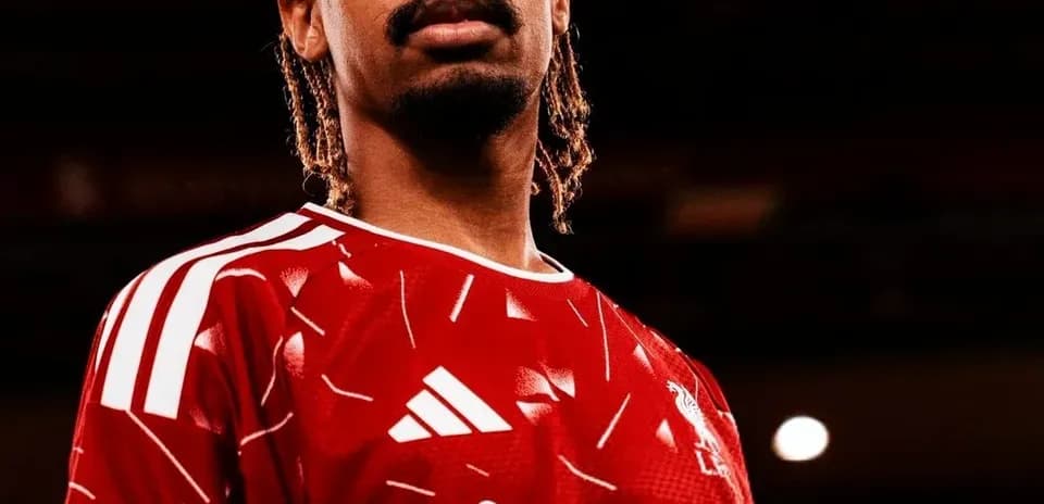 Player wearing red Liverpool jersey posing confidently