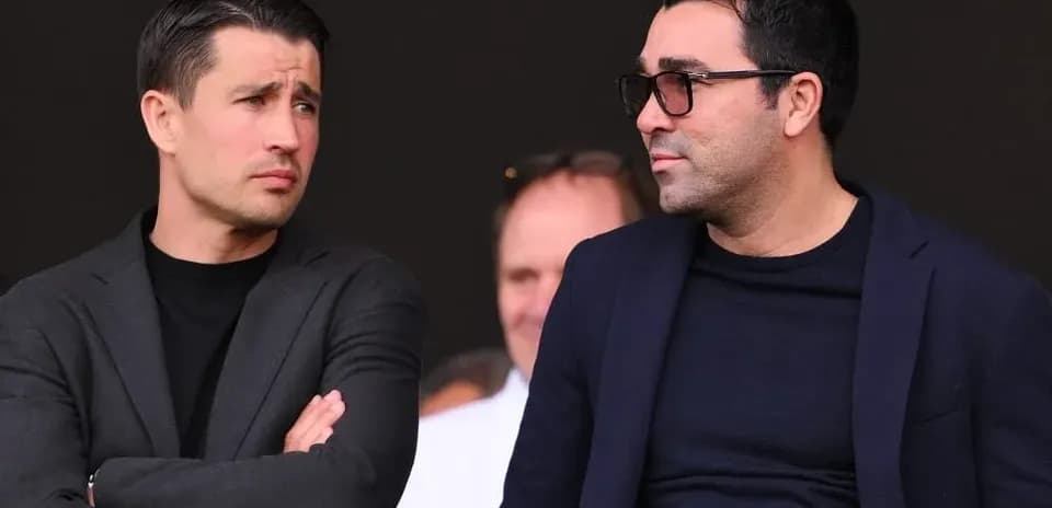 Two men in suits watching an event