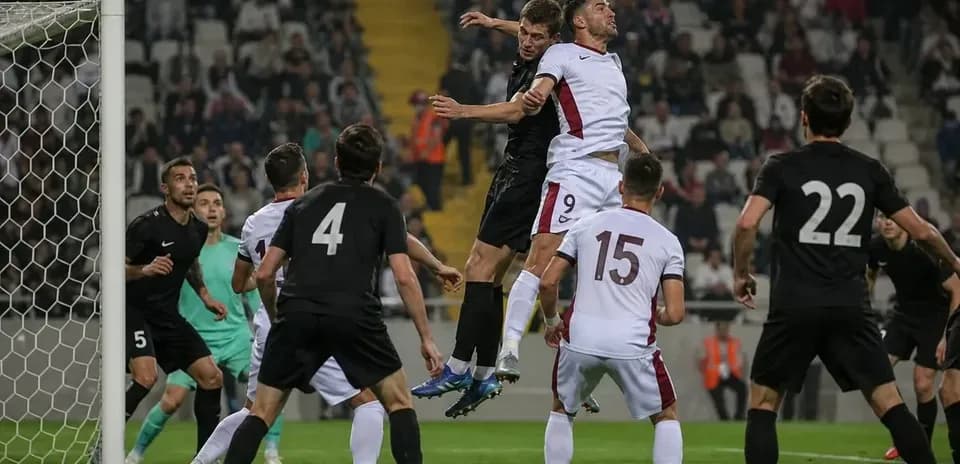 Players competing for a header near the goal
