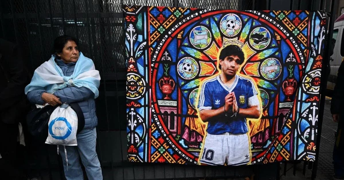 Woman standing beside mural of Diego Maradona