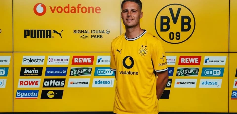 Player posing in Borussia Dortmund jersey at press event