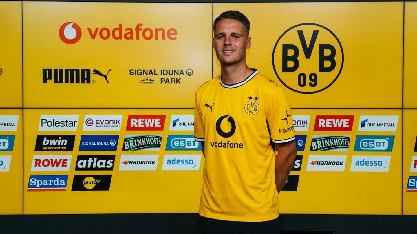 Player posing in Borussia Dortmund jersey at press event