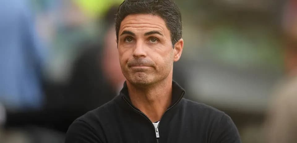 Coach observing match from sidelines with focused expression
