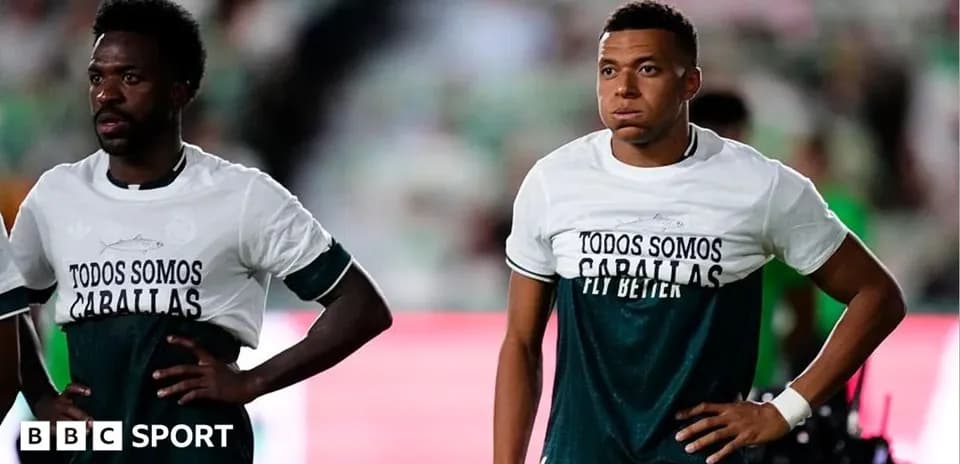 Two players wearing matching shirts on the pitch