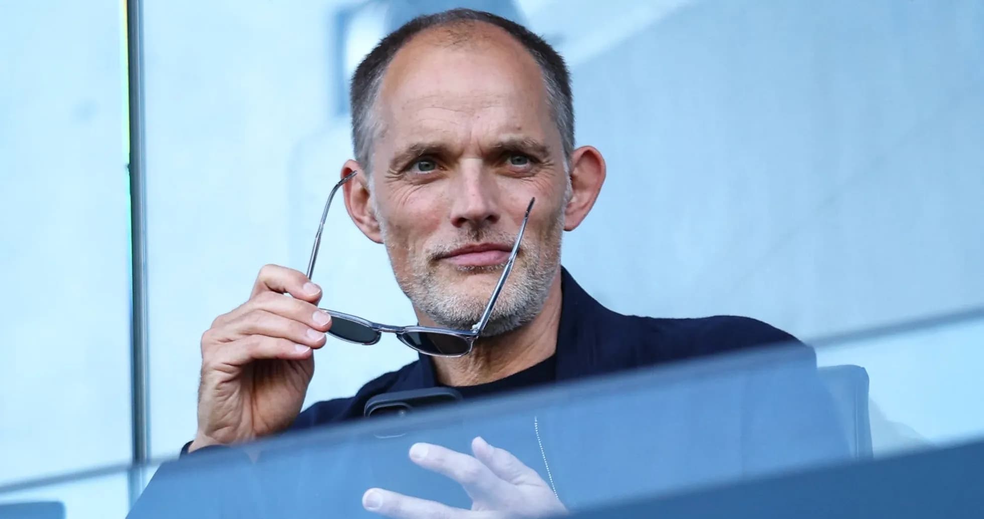 Man holding glasses while looking at phone