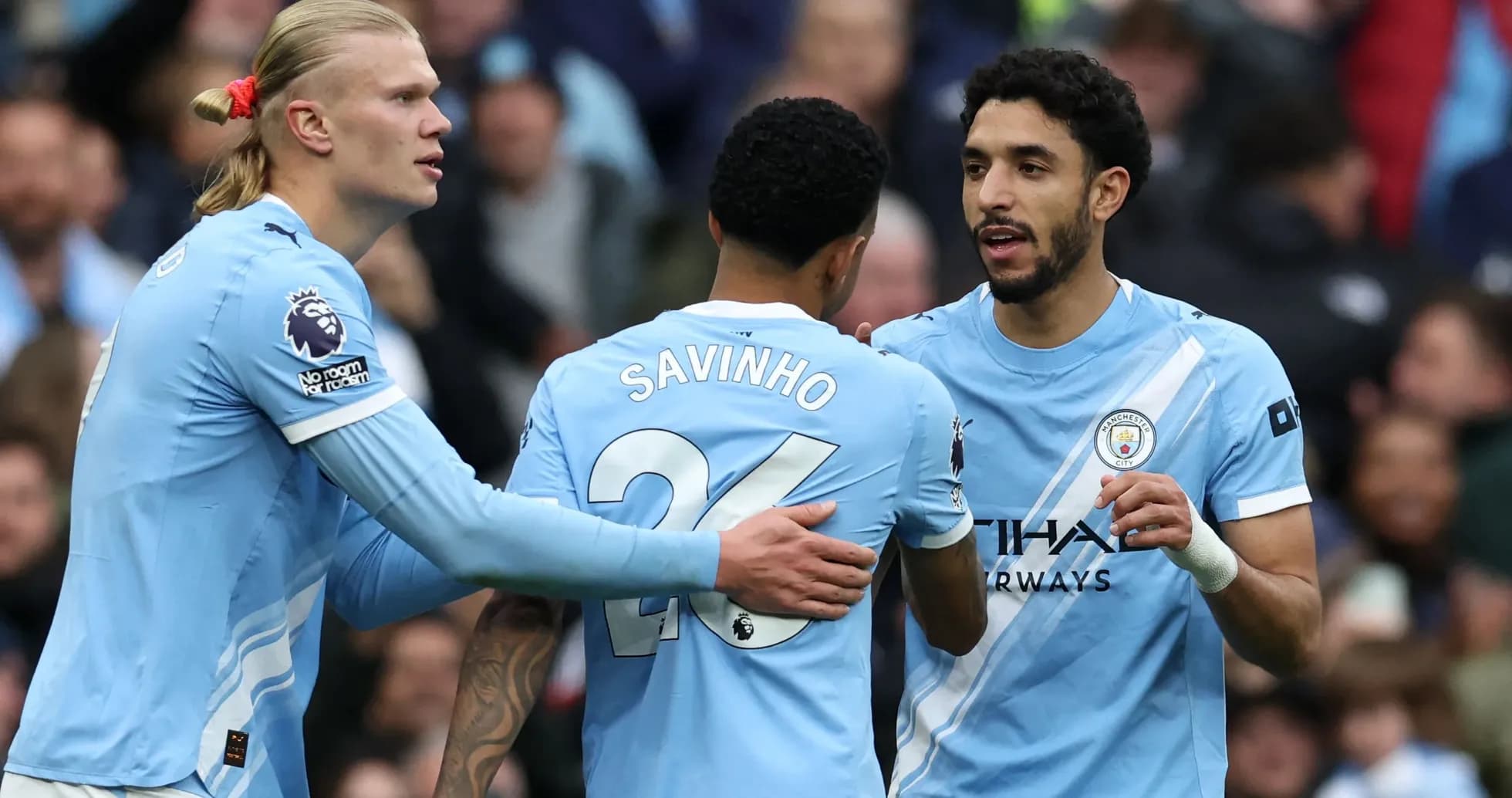 Three Manchester City players celebrating on the field