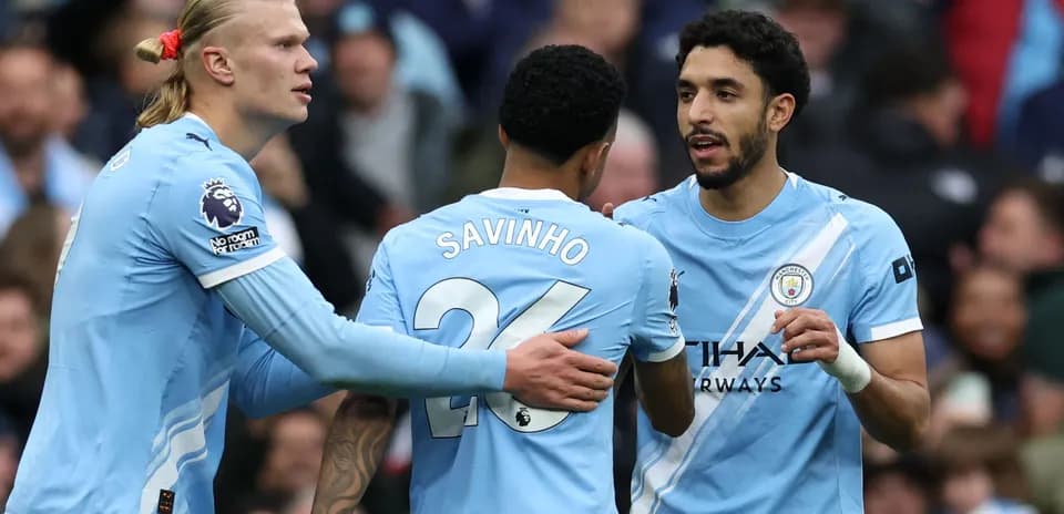 Three Manchester City players celebrating on the field