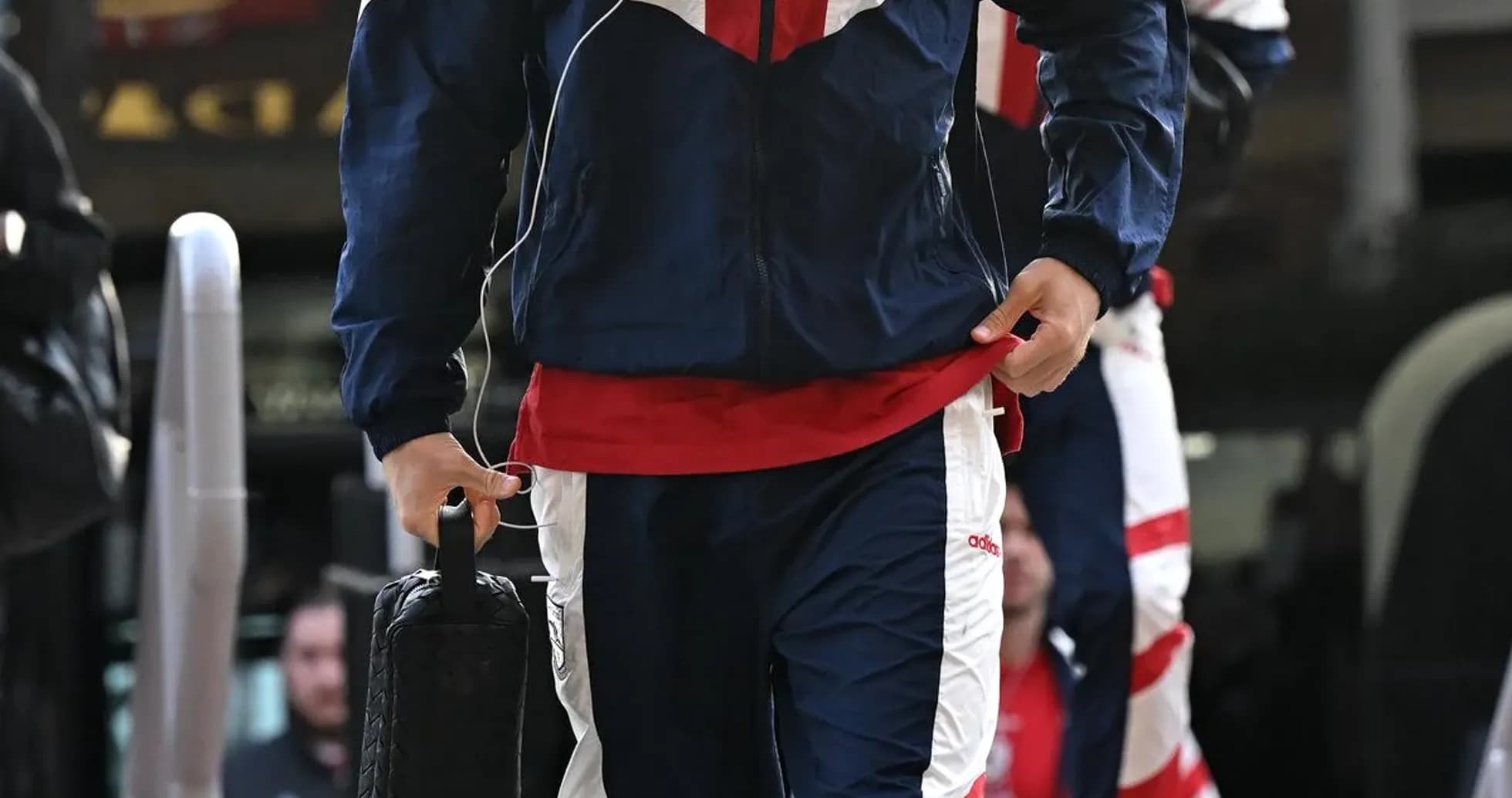 Player in tracksuit arriving with bag