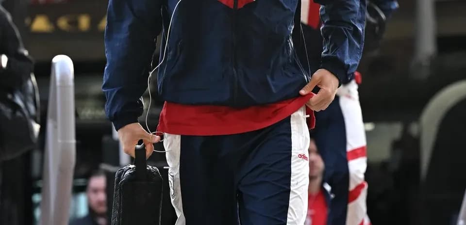 Player in tracksuit arriving with bag