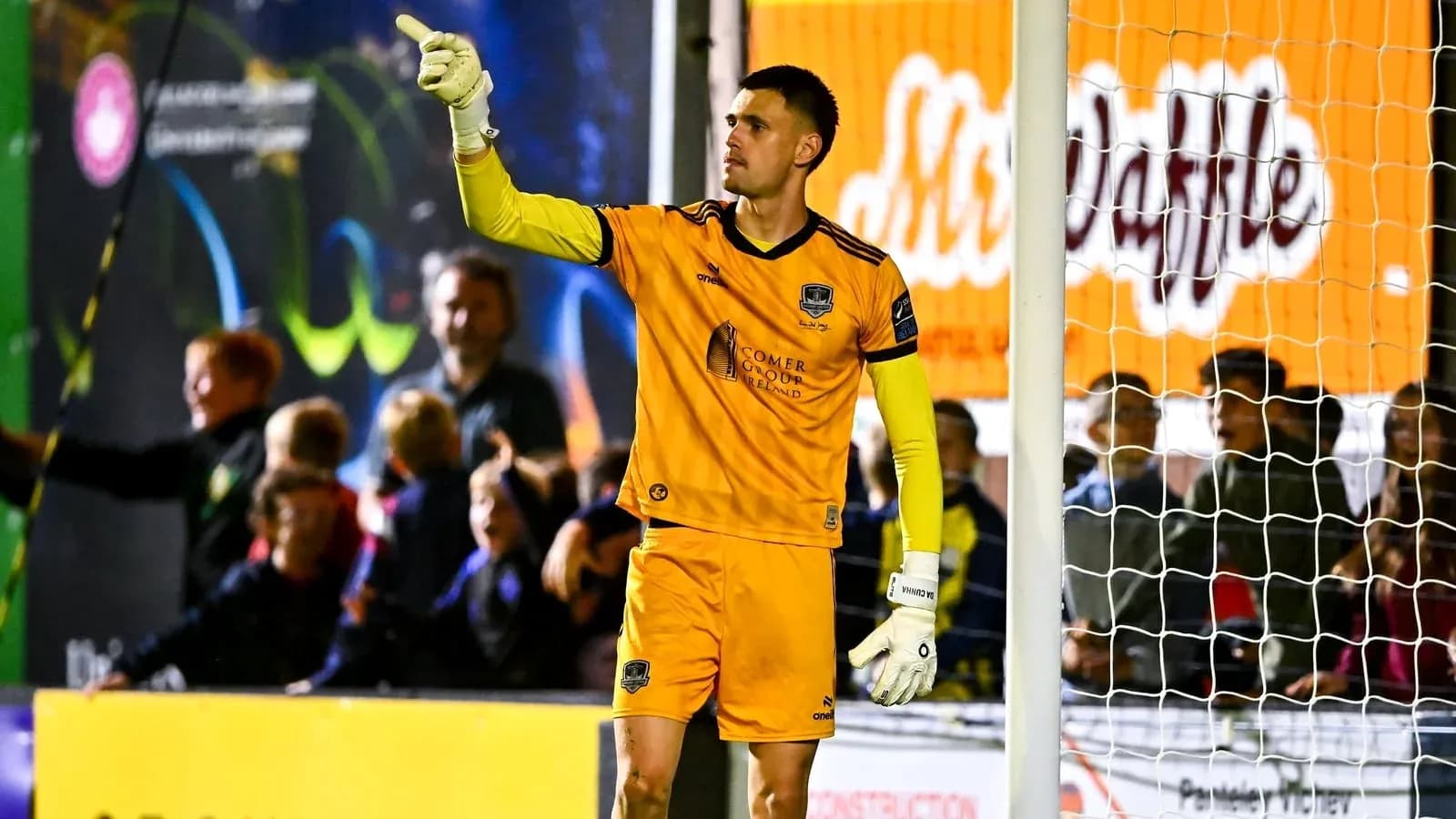 Goalkeeper signaling during a match with fans behind