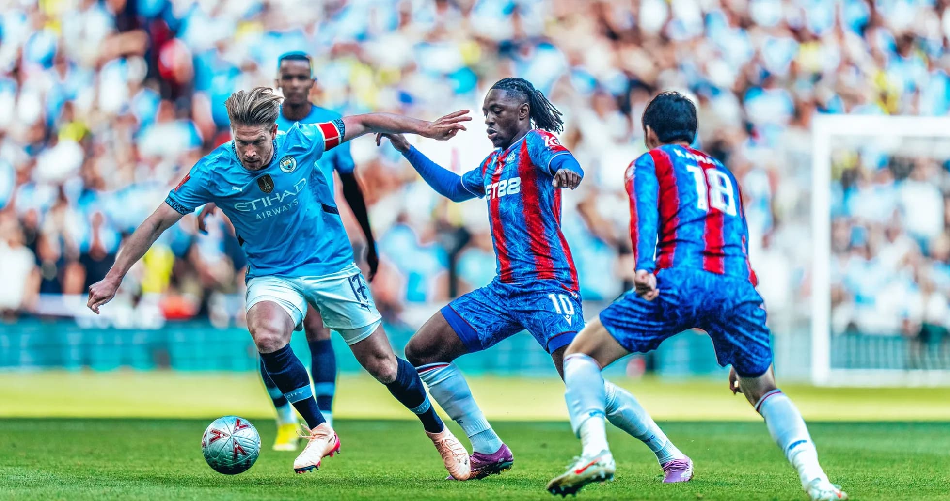Manchester City player dribbling past Crystal Palace defenders