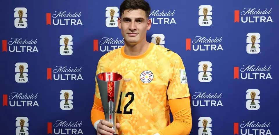 Goalkeeper holding trophy in press conference setting