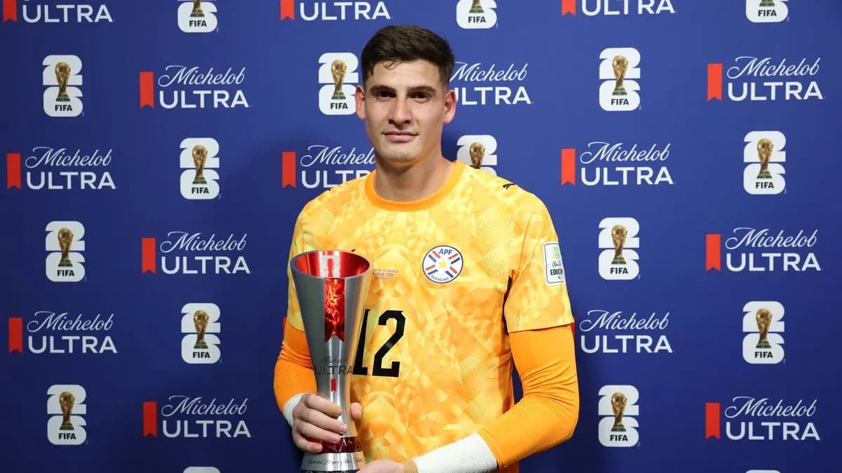 Goalkeeper holding trophy in press conference setting