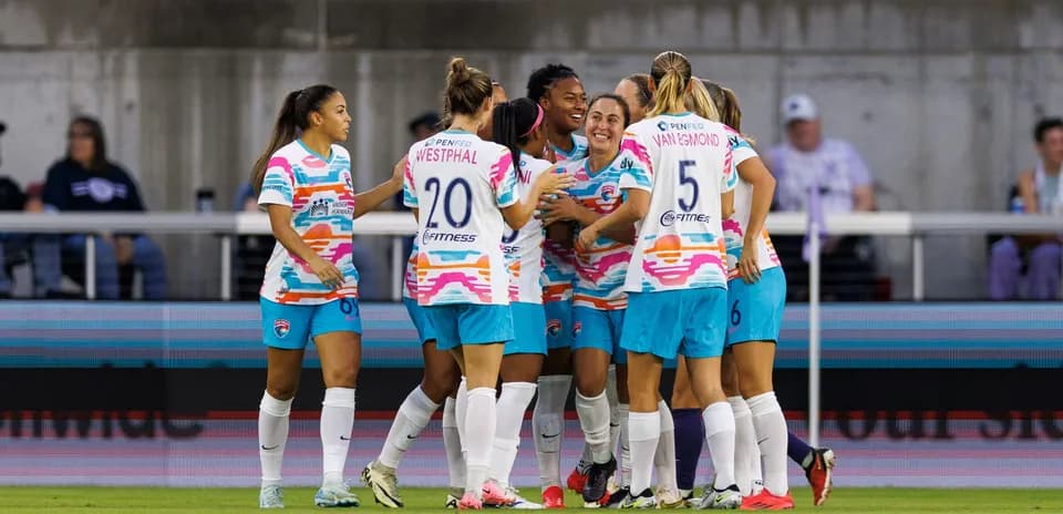 Players celebrating a goal during NWSL match
