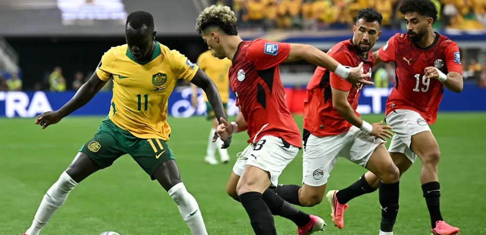 Player in yellow dribbling past defenders in red