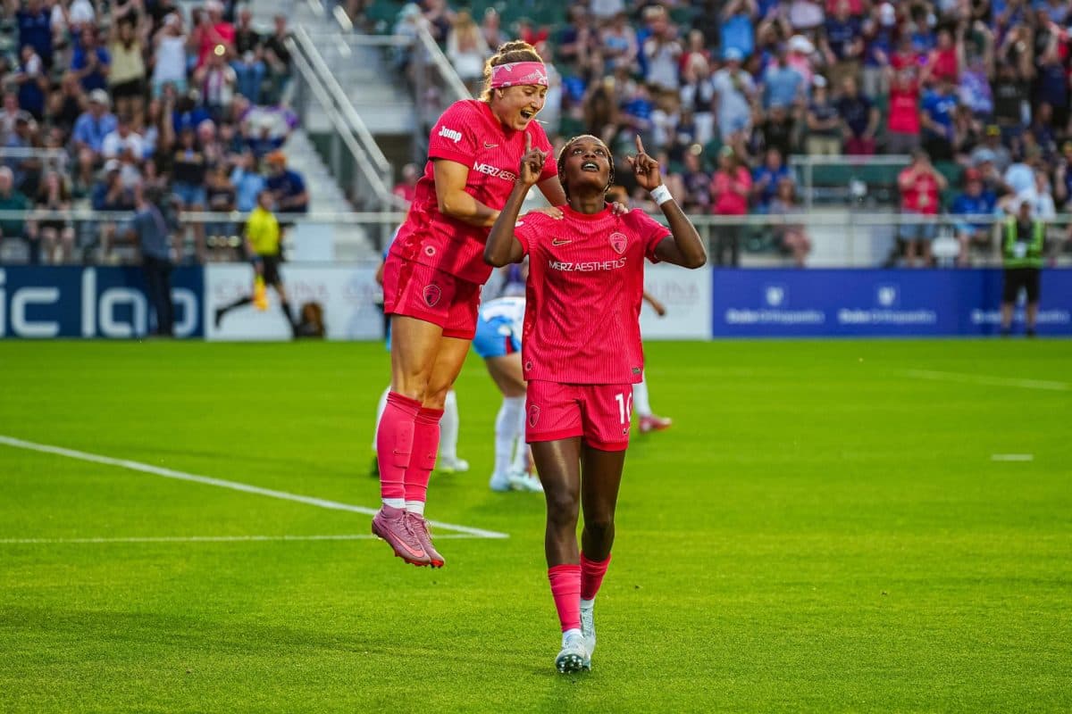 Players celebrating a goal during NWSL match