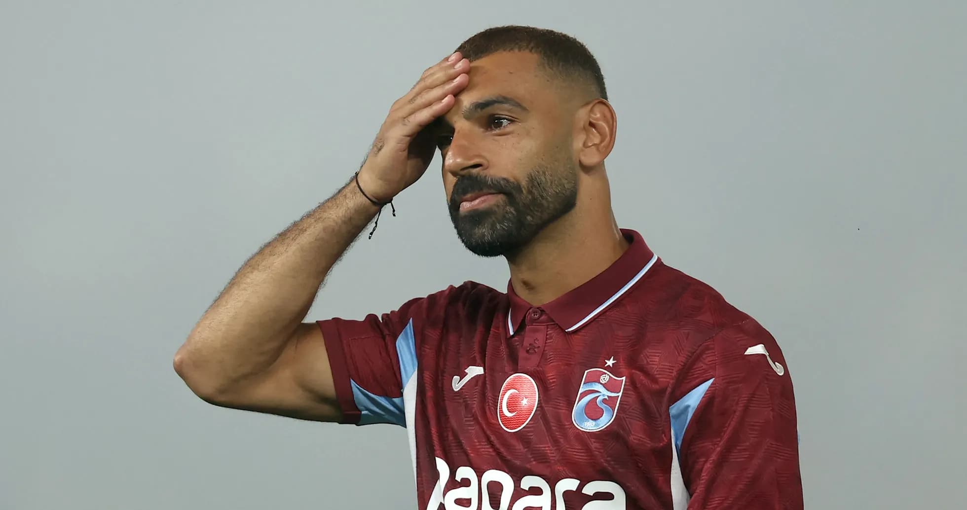 Player wearing maroon jersey at press event