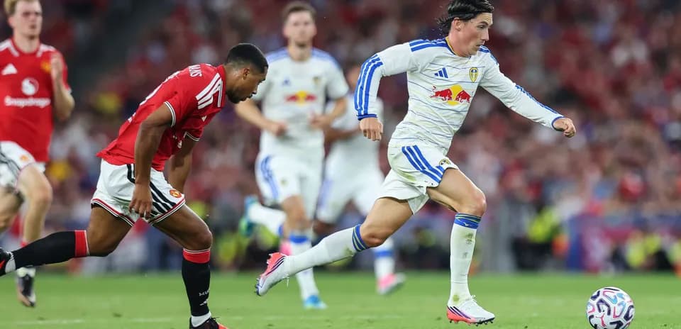 Leeds player sprinting with ball against Manchester United