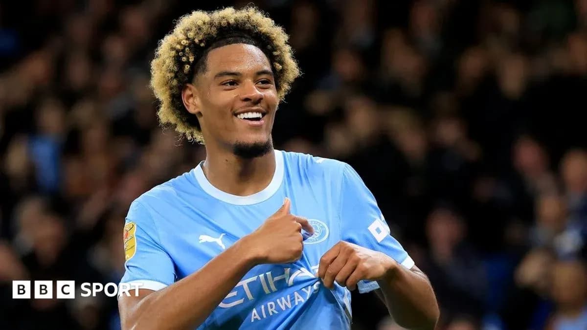 Player celebrating with thumbs up in Manchester City kit