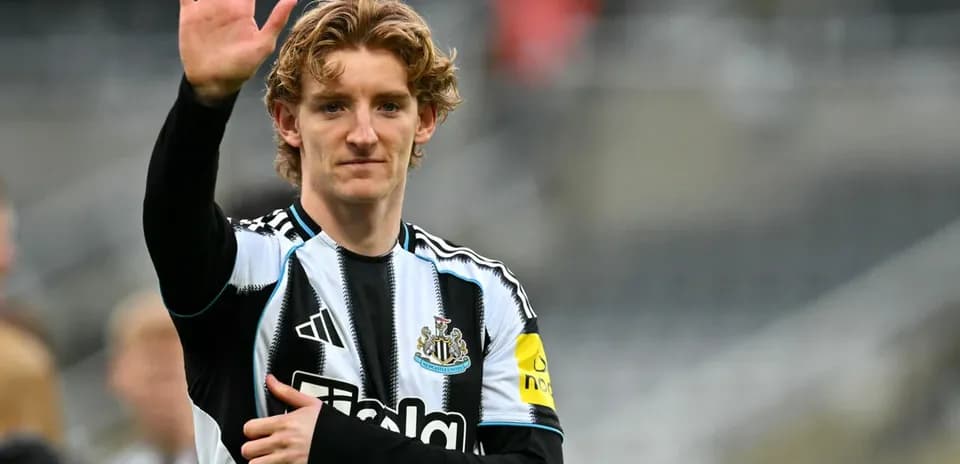 Player waving while wearing Newcastle United kit