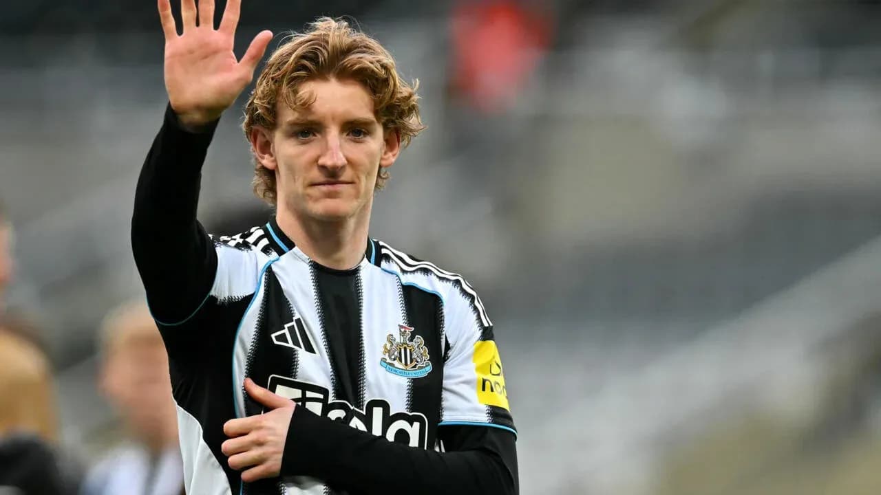 Player waving while wearing Newcastle United kit
