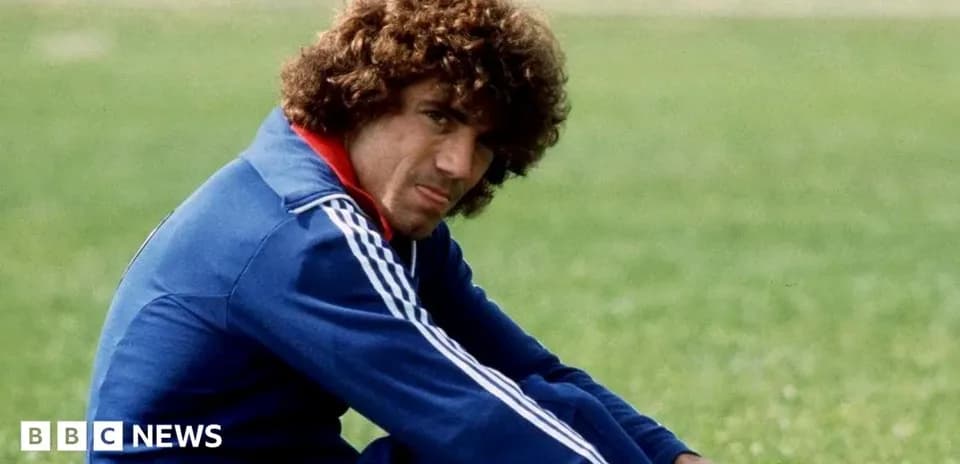 Football player sitting on grass field in training gear