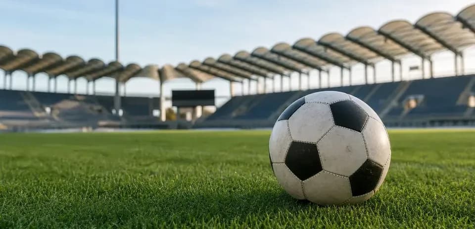 Soccer ball on grass field in empty stadium