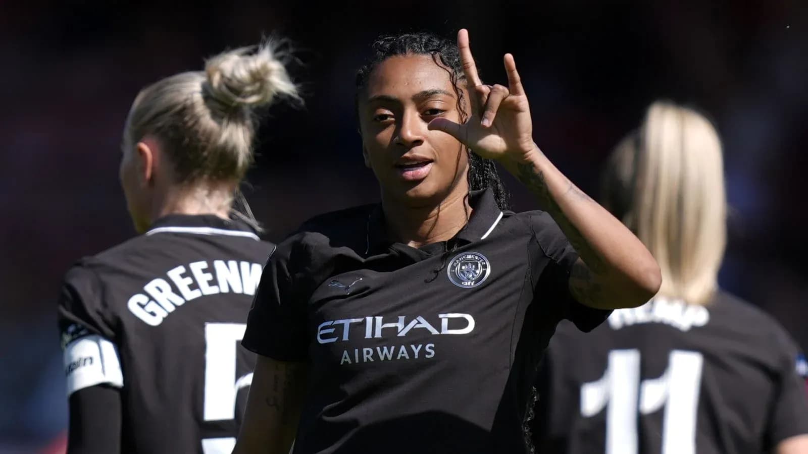 Player gesturing while teammates stand behind her